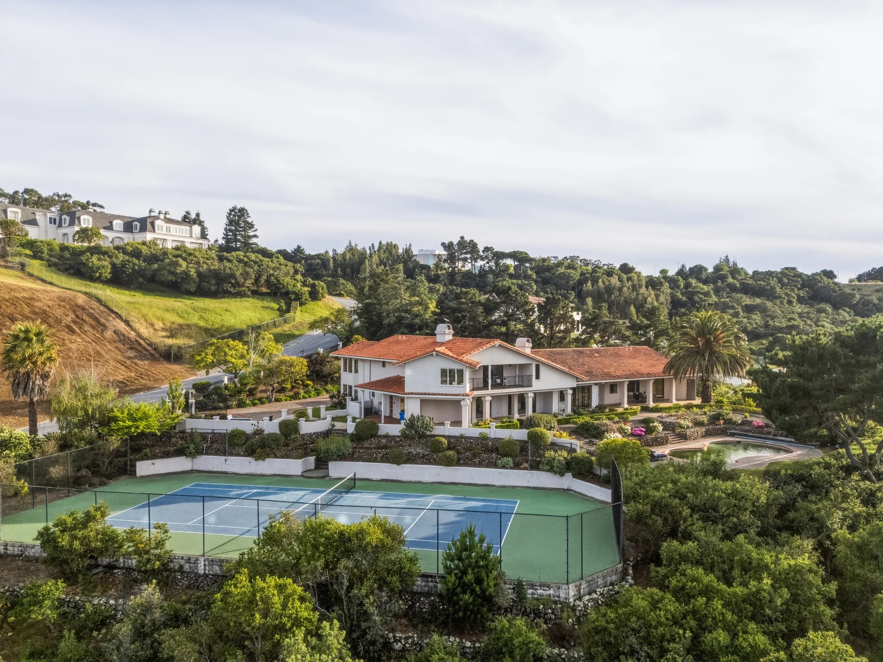 Aerial view of 200 Tobin Clark Drive, with the home and tennis court in the foreground.