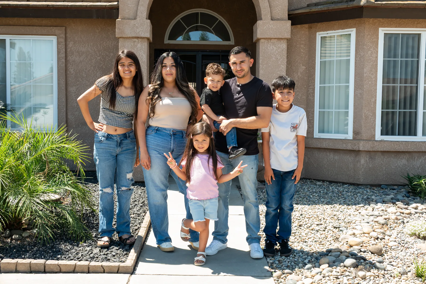 Group poses outside the home near the front entry.
