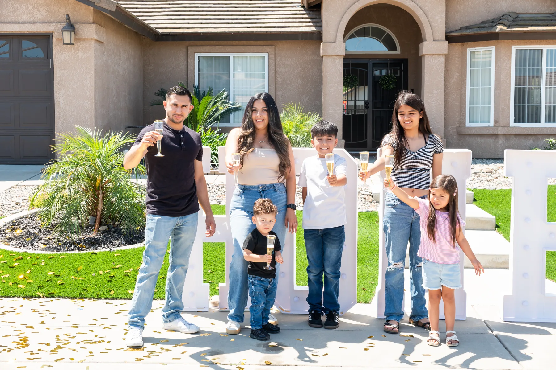 Group poses together in front of the house.